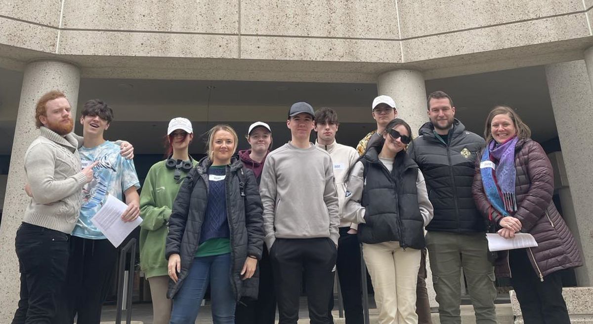 Nine students with tutors and guide outside BMI Building in Nashville